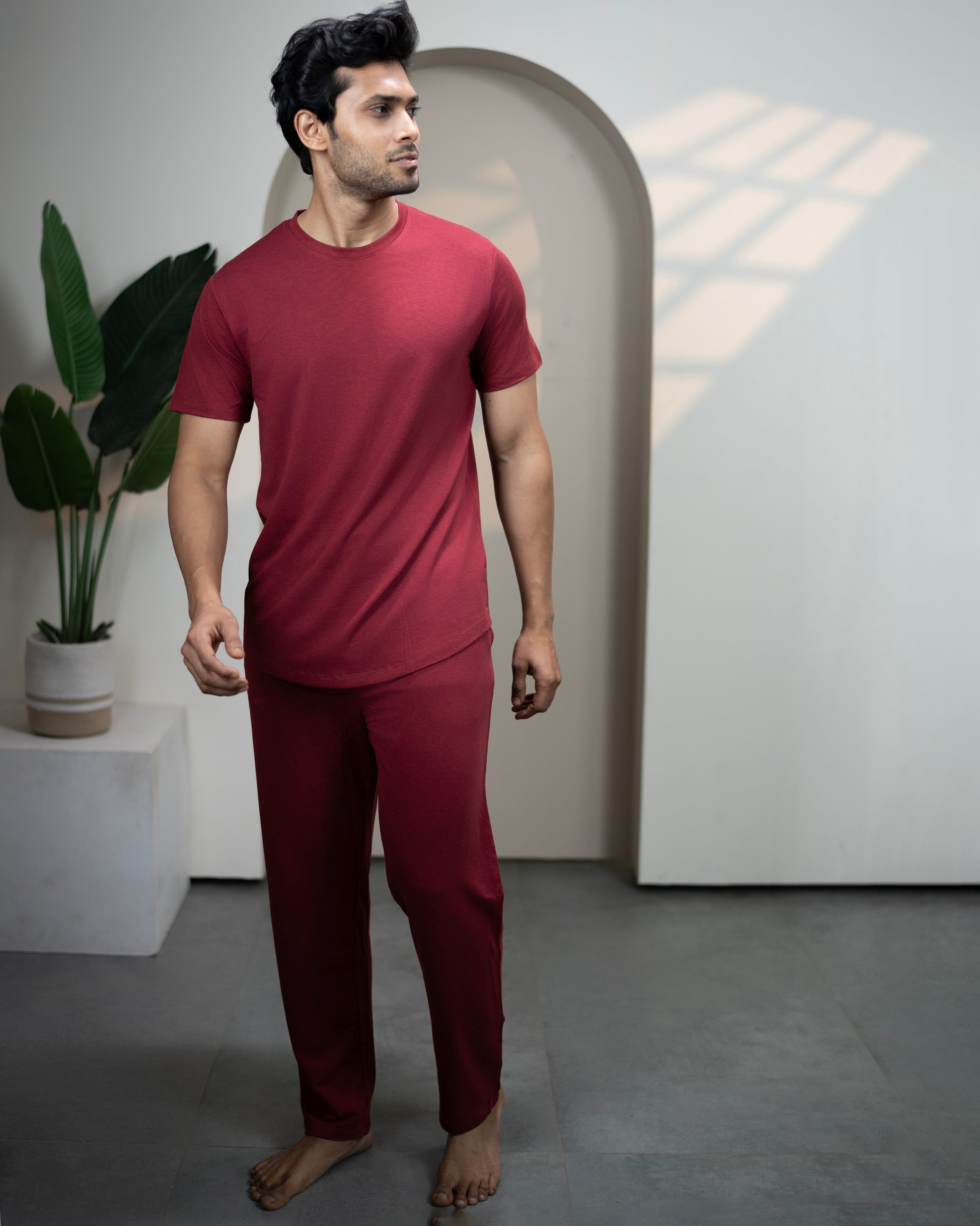 Man wearing a red outfit standing in a minimalistic room with a plant and archway. Cosmo Bamboo T-Shirt Wine Maroon for women
Soft smooth bamboo knit fabric
Eco conscious sustainable t-shirt
Casual wear bamboo tee top
Everyday essential bamboo t-shirt
Wine Maroon bamboo pants for women from the Urbanite sleepwear collection
Urbanite Bamboo Pant Wine Maroon color, soft stretch bamboo viscose
Women’s bamboo loungewear pants in Wine Maroon shade
Soft bamboo sleep pants Wine Maroon, gentle on sensitive skin
Urb
