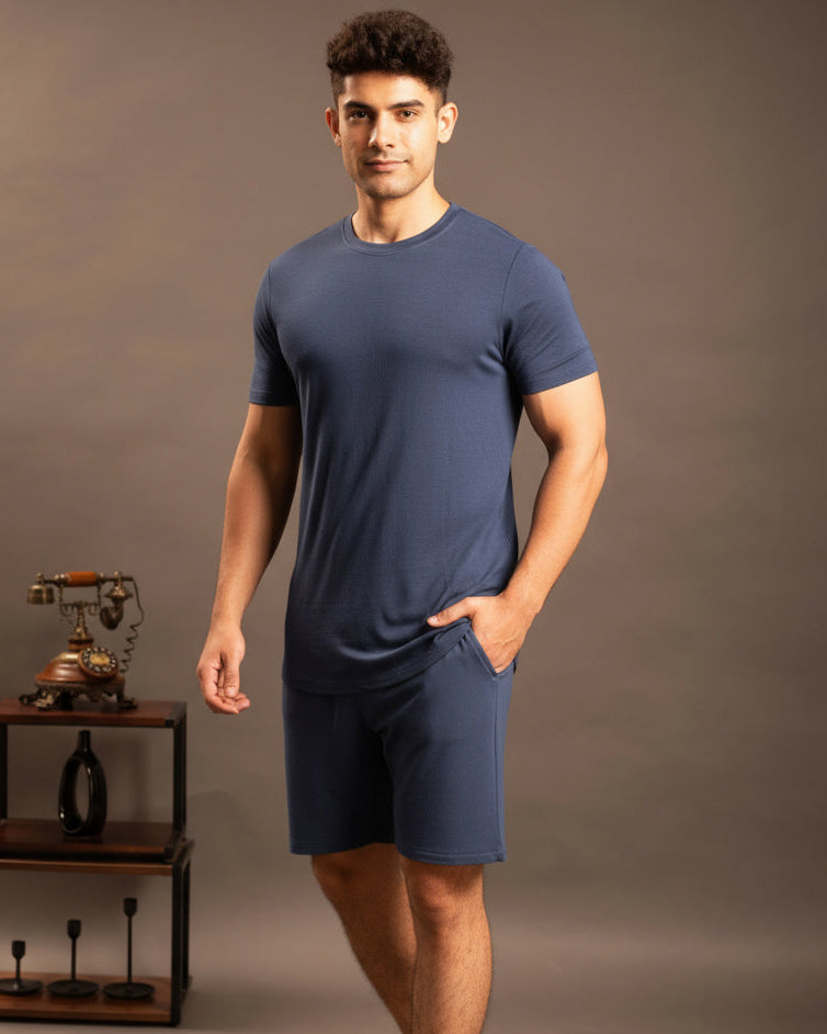 Man wearing a blue outfit standing against a brown background Cosmo T-Shirt + Shorts set in Navy Blue
Soft breathable fabric t-shirt and shorts
Women’s comfortable everyday lounge set
Eco friendly lightweight casual wear
Navy Blue cozy T-Shirt + Shorts set
